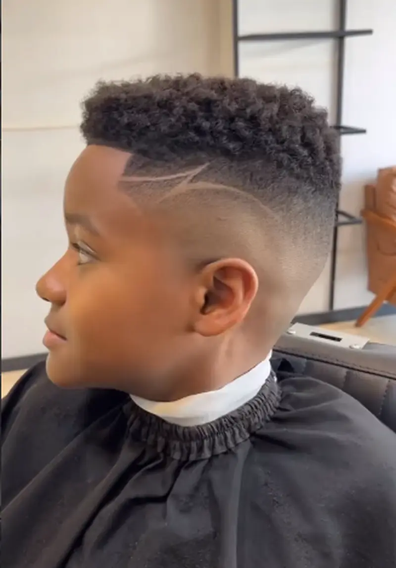 Criança sendo atendida durante o corte de cabelo infantil