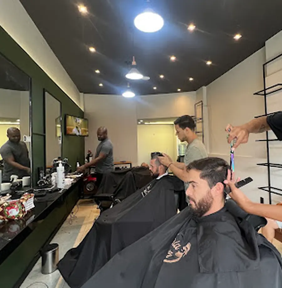 Barbeiros da Espaço Muniz em atendimento na barbearia