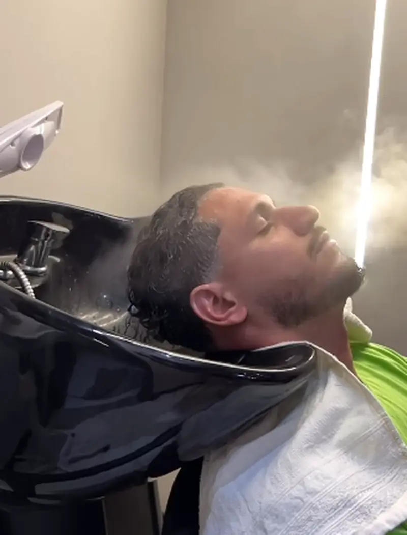 Lavagem de cabelo no lavatório durante o atendimento na barbearia